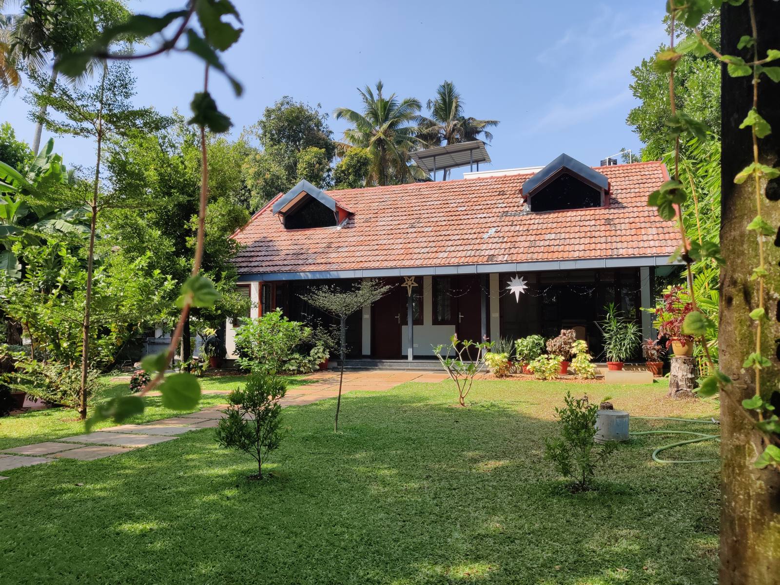 The retro-style cottage with its red tiled roof, seen across the garden lawn
